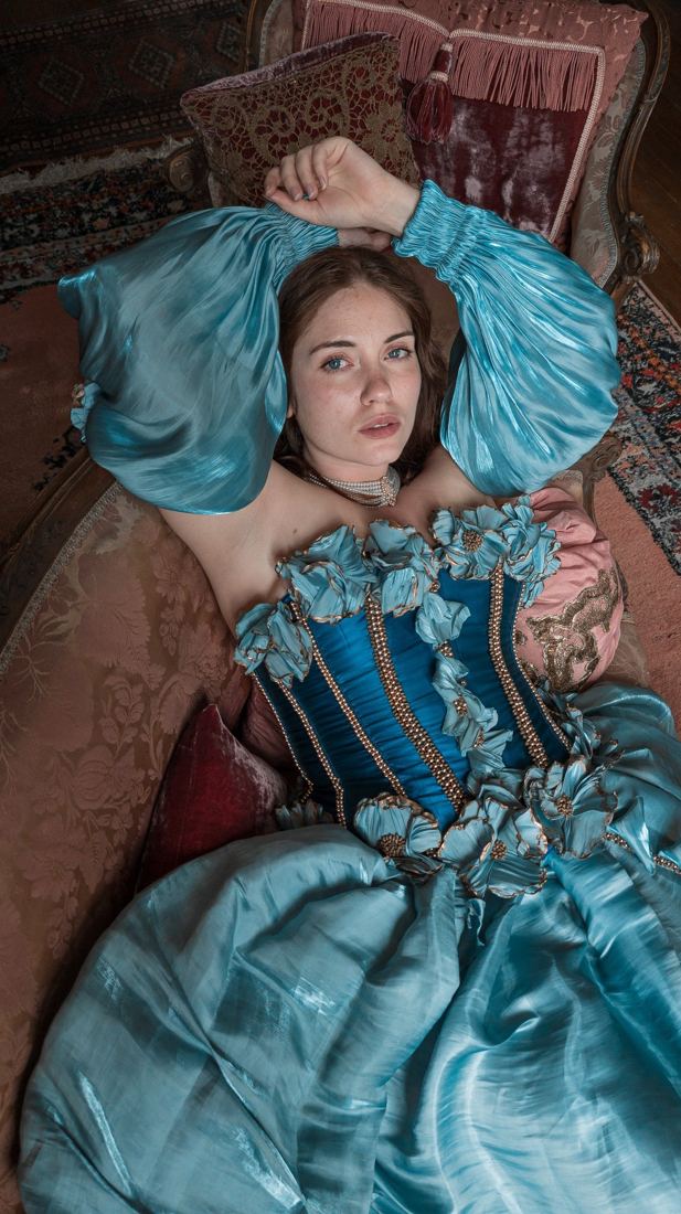 Modèle en robe d’époque bleue et chapeau