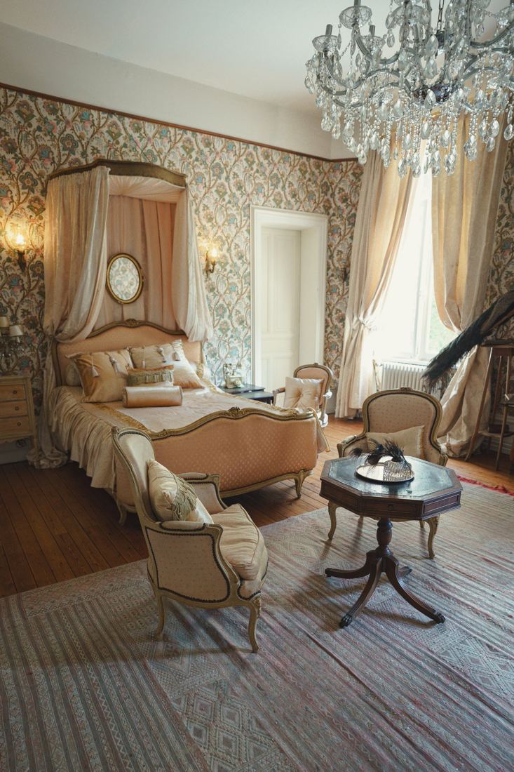 Chambre rococo avec lit à baldaquin et lustre