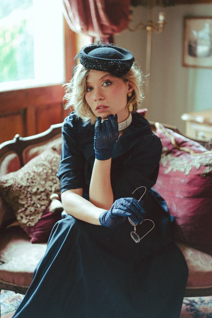Modèle en tenue rétro et béret dans un salon