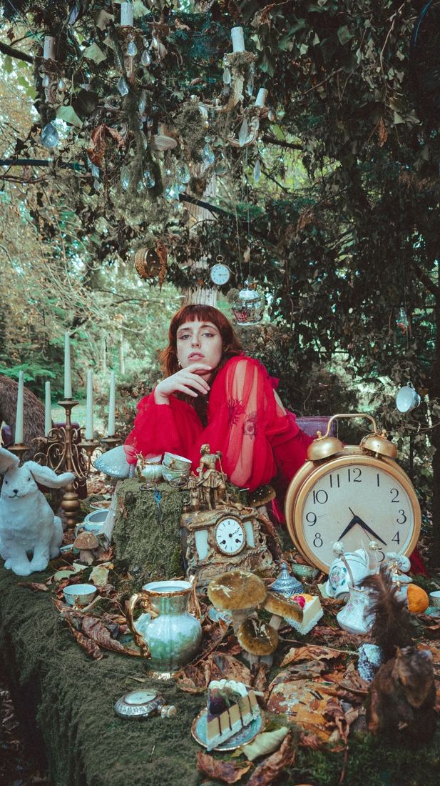 Modèle en rouge parmi les horloges et la verdure
